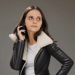 Une femme en cuir parle au téléphone portable de sexe anal sur pornhub
